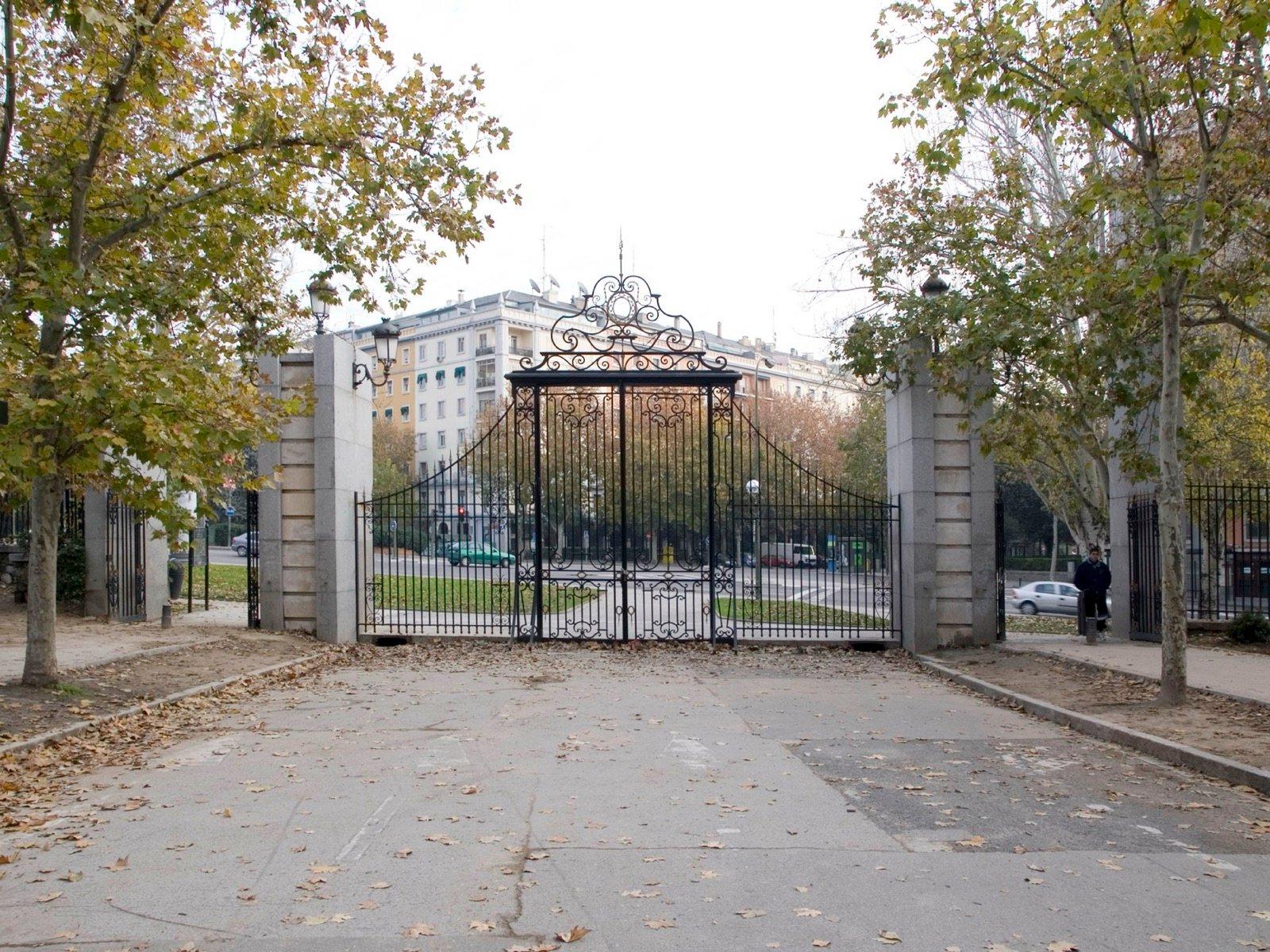 Vista completa de la cancela de forja de la Puerta del Niño Jesús desde el interior del parque